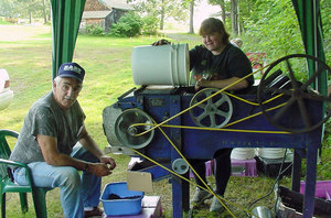Two people working the antique winnower